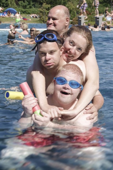 Auf dem 2. Bild sieht man 4 Menschen mit und ohne Beeintrchtigung unterschiedlichen Alters, die zusammen Spa im Schwimmbad haben.