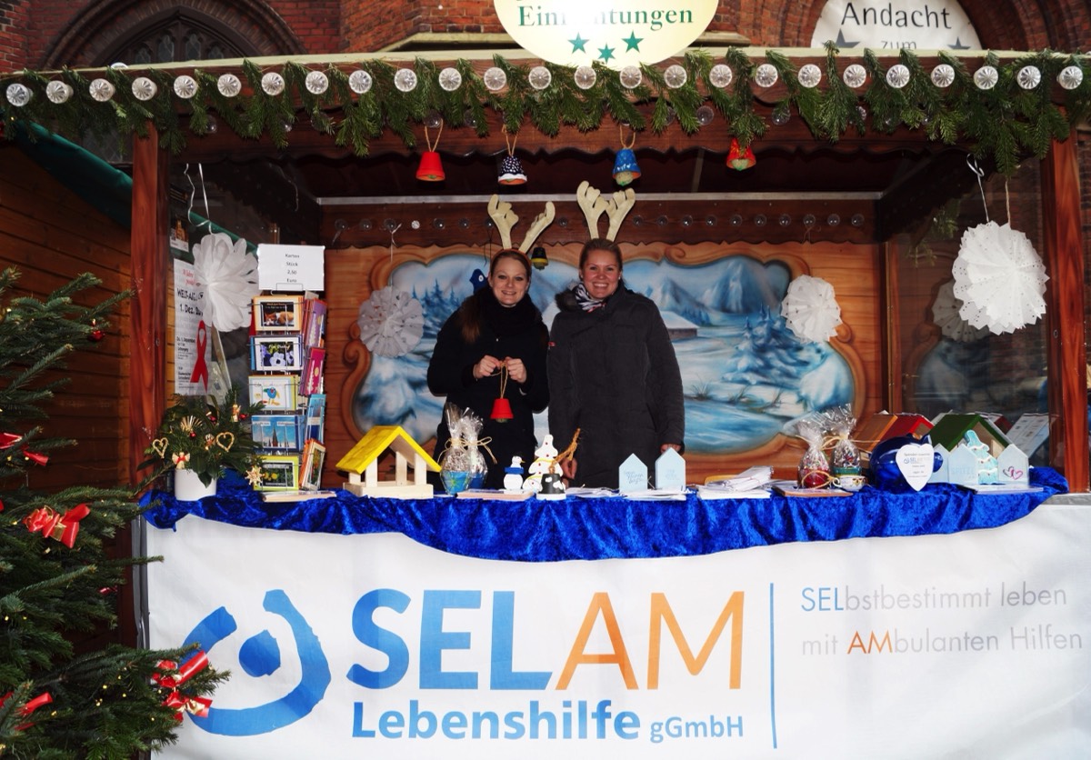 Auf dem 1. Bild sieht man zwei Mitarbeiterinnen in der sozialen HÃ¼tte auf dem Lambertimarkt. Dort verkauft die SELAM-Lebenshilfe jedes Jahr an einem Tag in der Adventszeit Produkte aus der TagesfÃ¶rderstÃ¤tte.